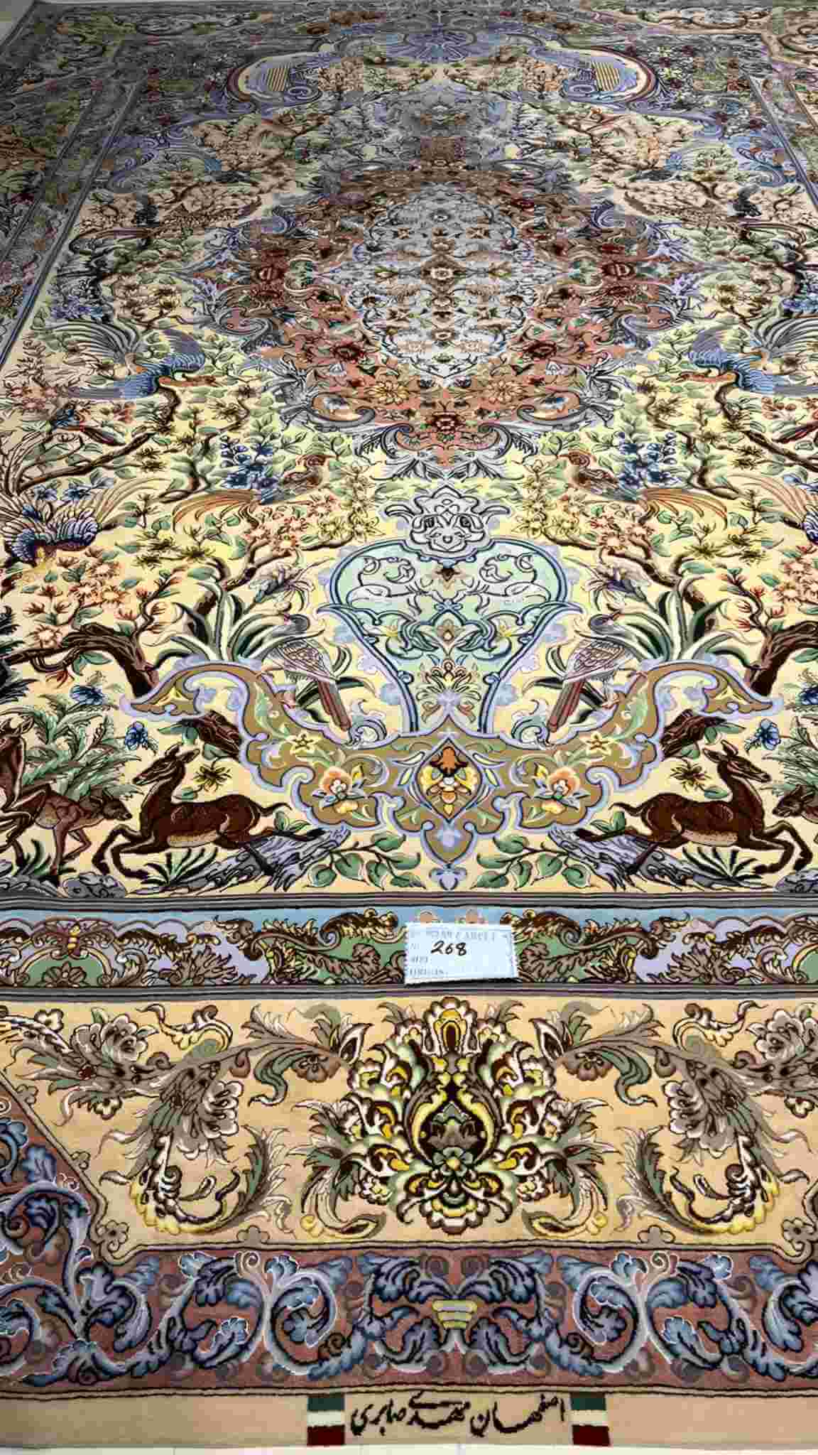 "Colorful Isfahan silk rug with intricate floral and animal motifs, 10.2 x 6.7 feet."